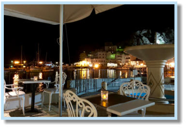 Vanaf het terras van La Corte mooi zicht op de gezellig verlichtte haven van Pigadia