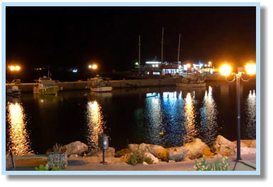 De lantaarns weerspiegelen op het water in de haven