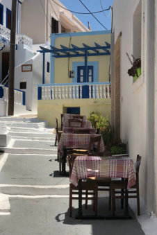 Eettafeltjes in een glooiend straatje in Arkasa Karpathos Griekenland