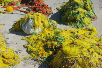 Kleurrijke gele vissersnetten drogen in de haven van Finiki