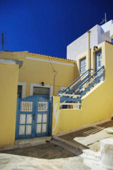 Het geel van dit huis steekt mooi af tegen de blauwe Griekse lucht